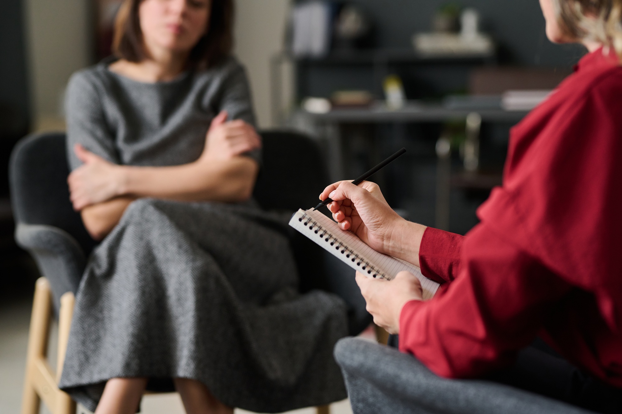 Counseling Psychologist Holding Notebook while Listening Patient