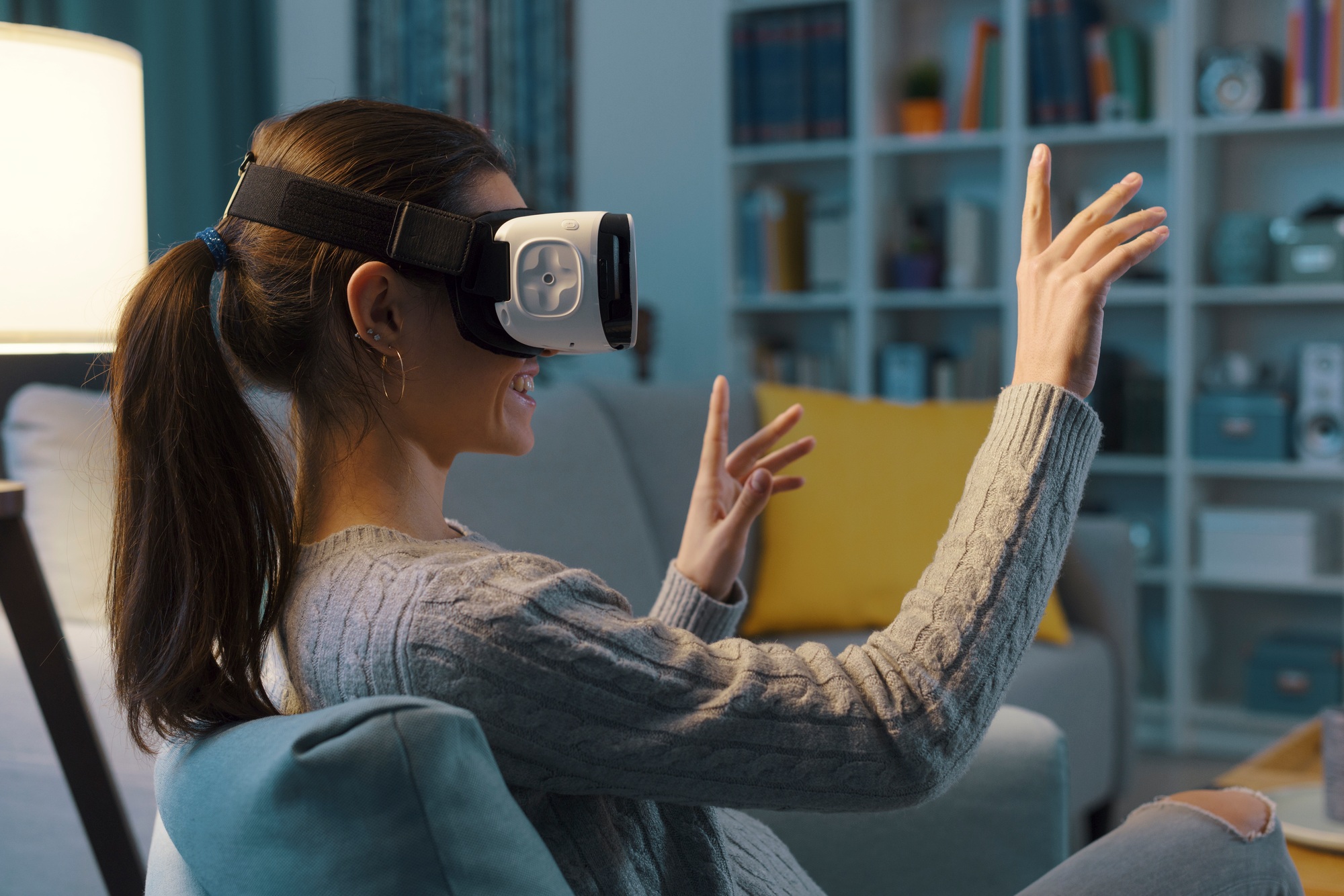 Woman relaxing on the sofa and interacting with virtual reality